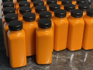 Organic sea buckthorn juice from Estonia bottled in square PET bottles with black lids