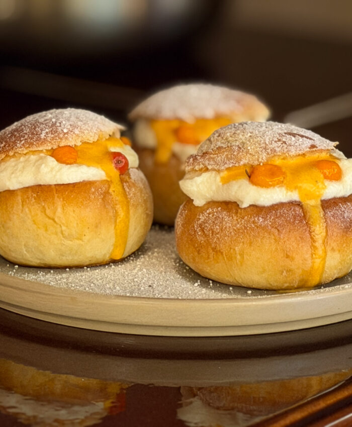Nordic semla filled with white chocolate cream and sea buckthorn sauce on a plate